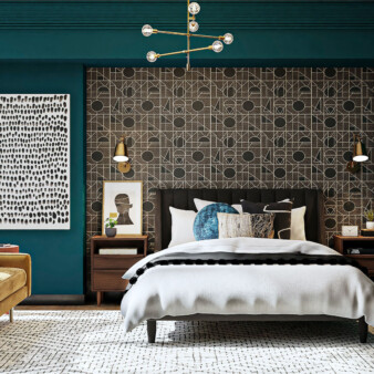 Modern bedroom with a playful combination of textures and dark earth tones. Walls are deep turquoise, queen-sized bed has a dark base board and night tables are made of dark wood. Behind the bed there is a large recessed space covered with a textured surface made of geometric figures in dark brown and off-white contour lines. On the left of the room, by a window, there is a modern suede sofa in deep mustard color with three pillows, one in a single color and the other two with designs that capture the colors of the room.