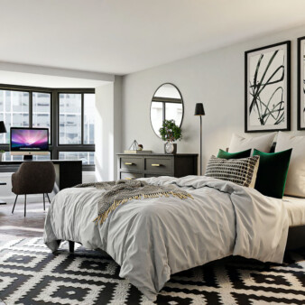 Spacious modern bedroom decorated in black, dark brown and white. Most of the furniture is made out of dark wood, and there is a dresser and a computer desk. Two pieces of abstract art made of black brush strokes with black frames hang on the wall behind the bedroom.